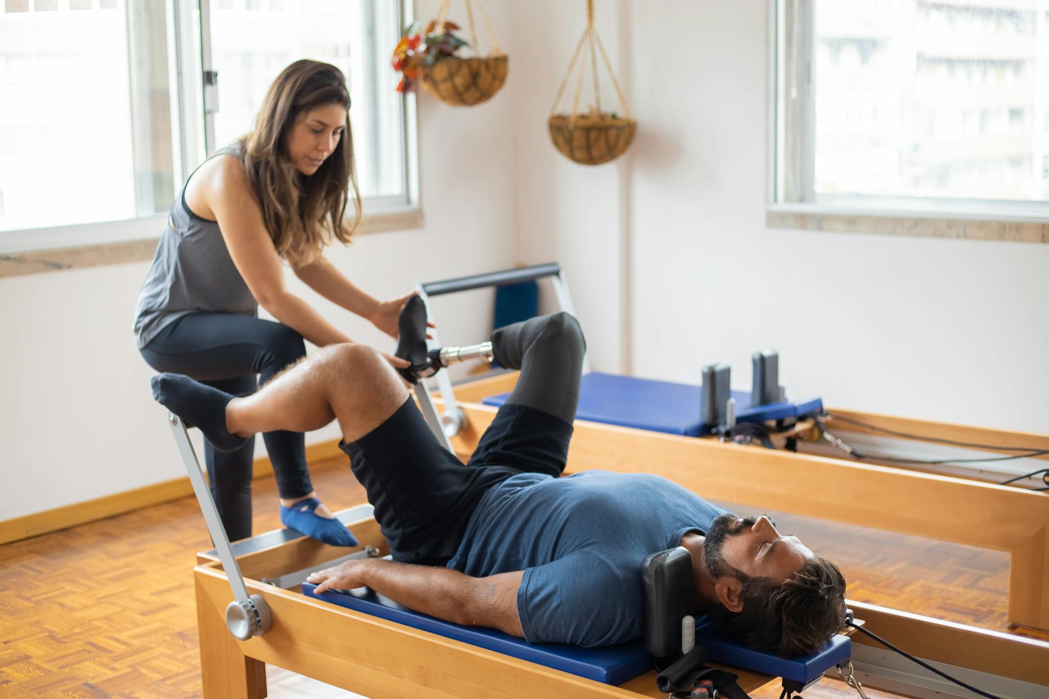 Adaptive pilates session with prosthetic leg focus on recovery and fitness indoors.
